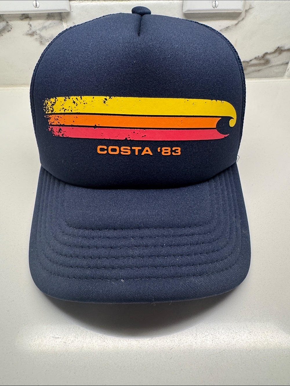 Costa 83’ vintage Navy Trucker Hat with Yellow and Coral Wave Graphic